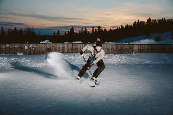 Hockey player skating on a backyard ice rink.
