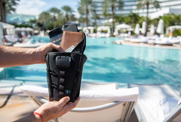 a person holding a flexsafe at a public swimming pool