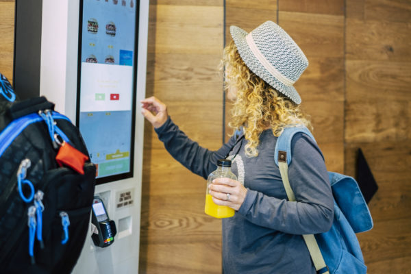 A woman order fast food at a kiosk