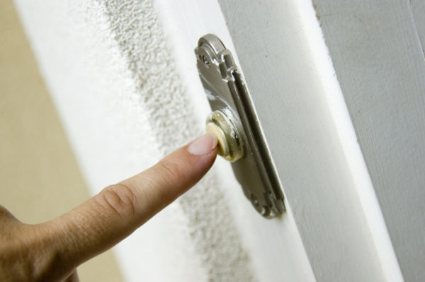 A finger ringing a doorbell