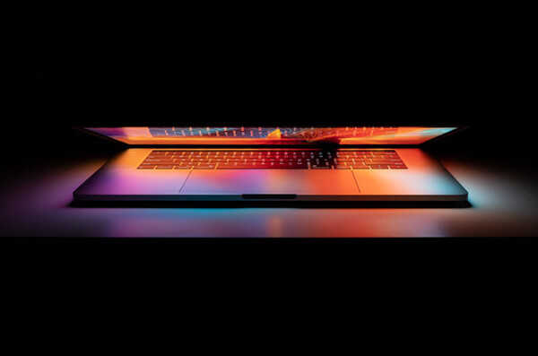 a half closed laptop with glowing neon colors