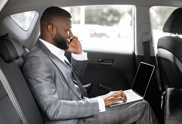 a businessman working in the backseat of a taxi