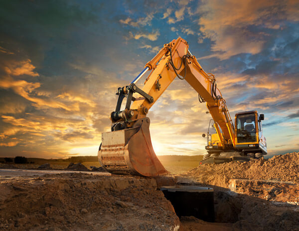 An excavator working at sunset
